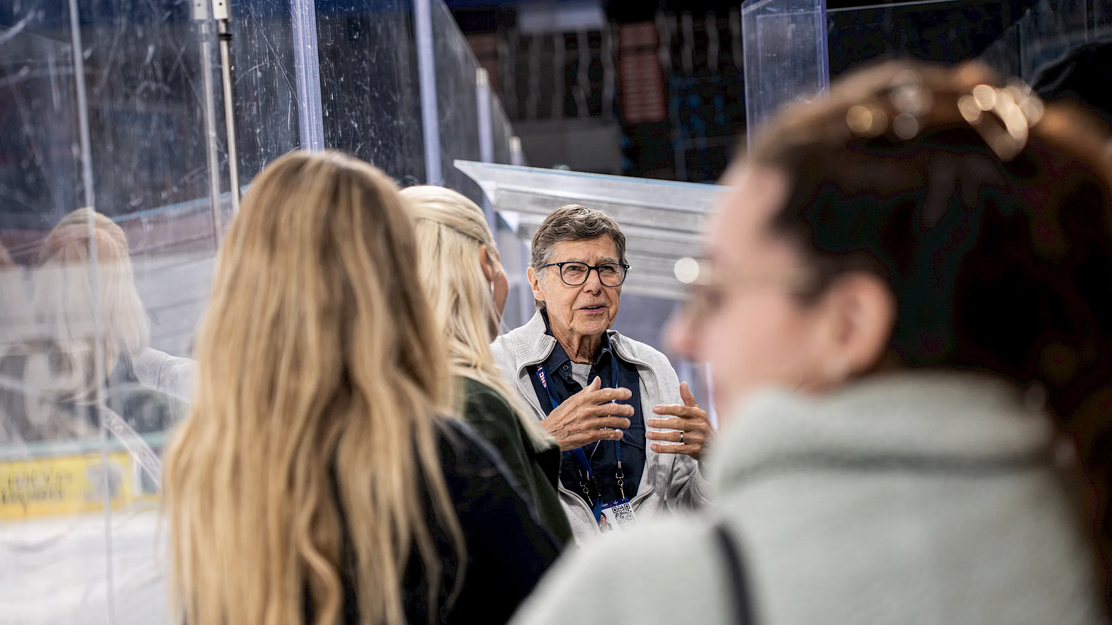 Guide erkl&auml;rt Besucherinnen bei einer Stadionf&uuml;hrung Details direkt am Eisfeld