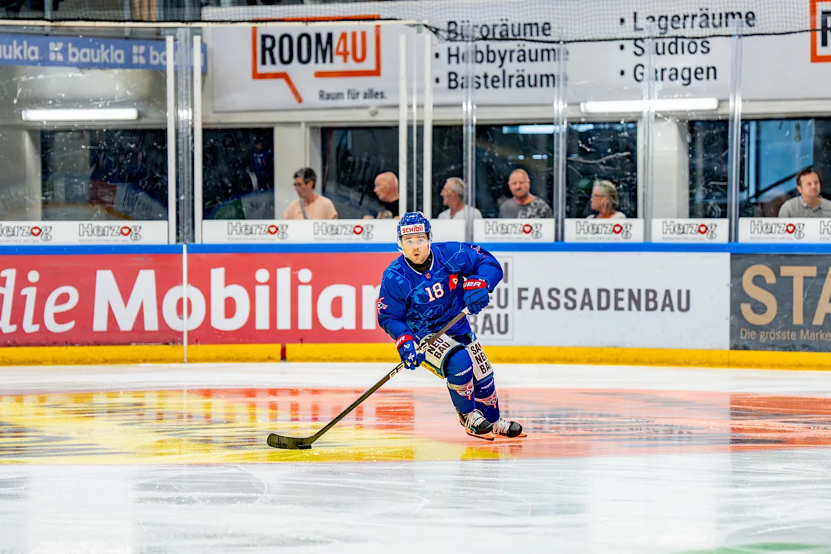 Dario Sidler in blauem EHC-Kloten-Dress mit Nummer 18 f&uuml;hrt den Puck &uuml;ber das Eis