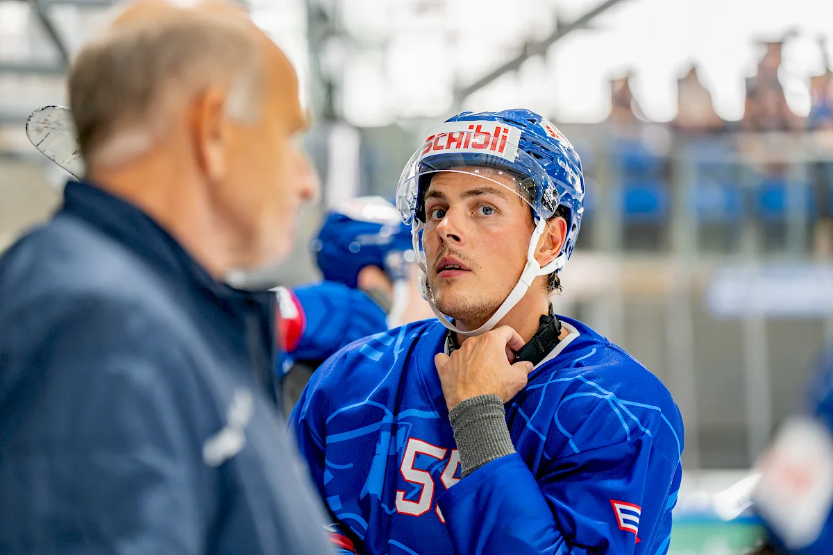 Max Lindroth mit Nummer 55 im blauen Trikot spricht mit einem Betreuer an der Bande