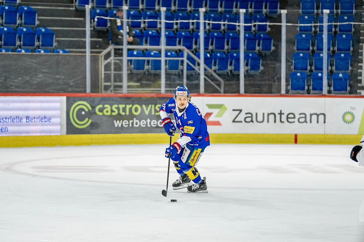 Mischa Ramel f&uuml;hrt im blauen EHC-Kloten-Trikot mit Nummer 14 den Puck &uuml;ber das Eis