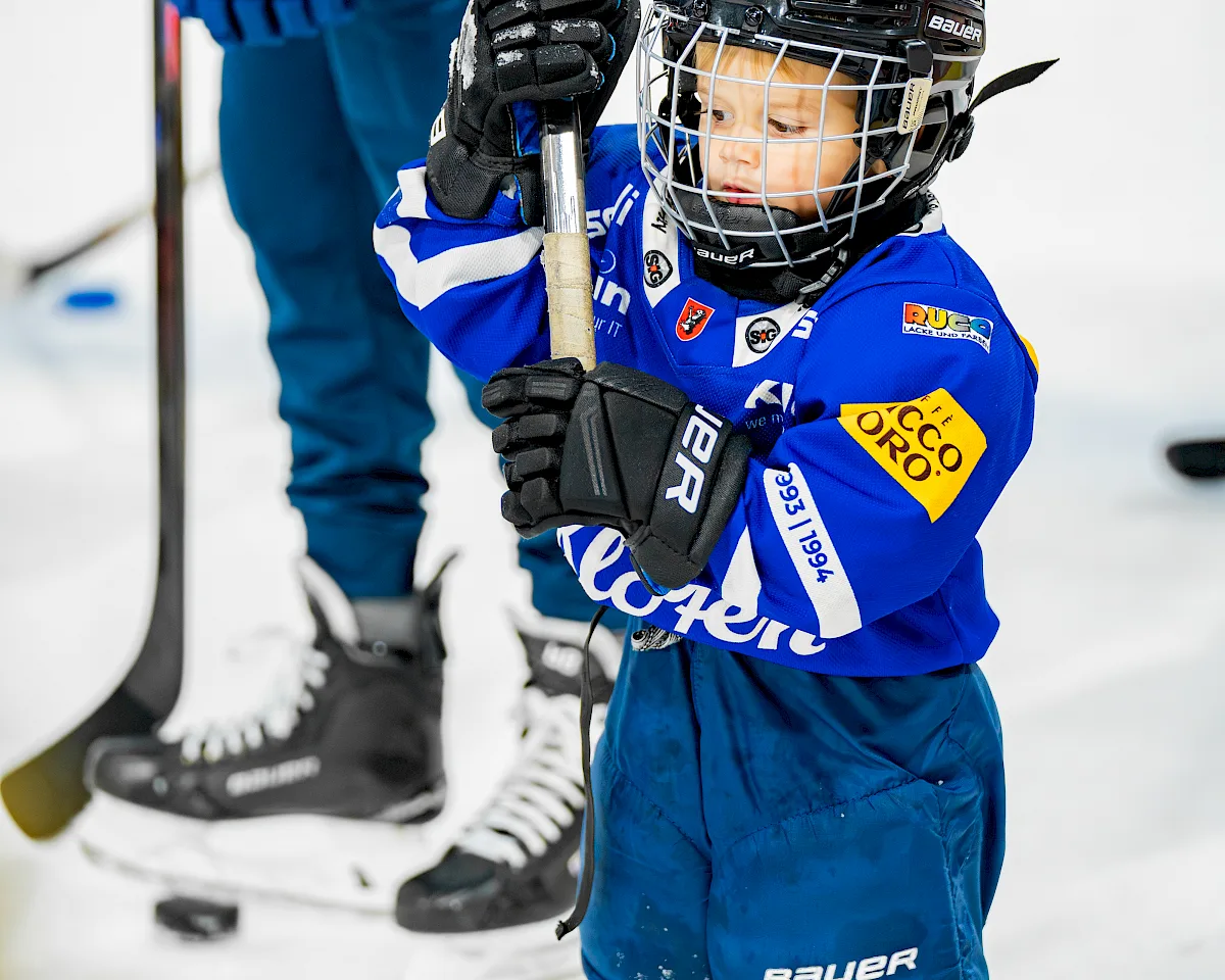 Kleiner U9-Spieler des EHC Kloten h&auml;lt Stock auf dem Eis, im Hintergrund ein Teamkollege