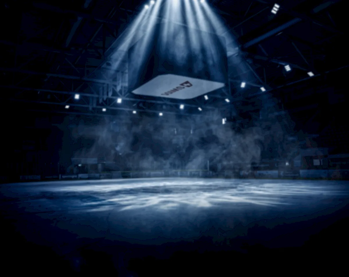 Beleuchtetes leeres Eisfeld mit Scheinwerferlicht und Nebel in der Eishalle