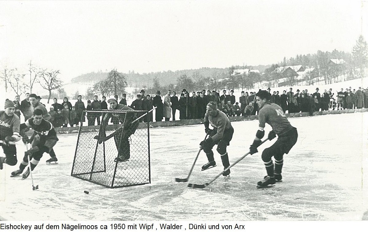 Eishockeyspiel auf dem N&auml;gelimoos-Weiher um 1950 mit Spielern vor Zuschauern am Eisrand