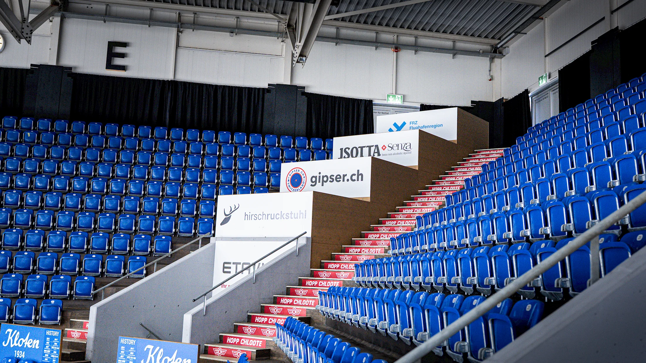 Ap&eacute;ro-Box in Sektor E mit Sponsorenlogos zwischen den blauen Trib&uuml;nensitzen