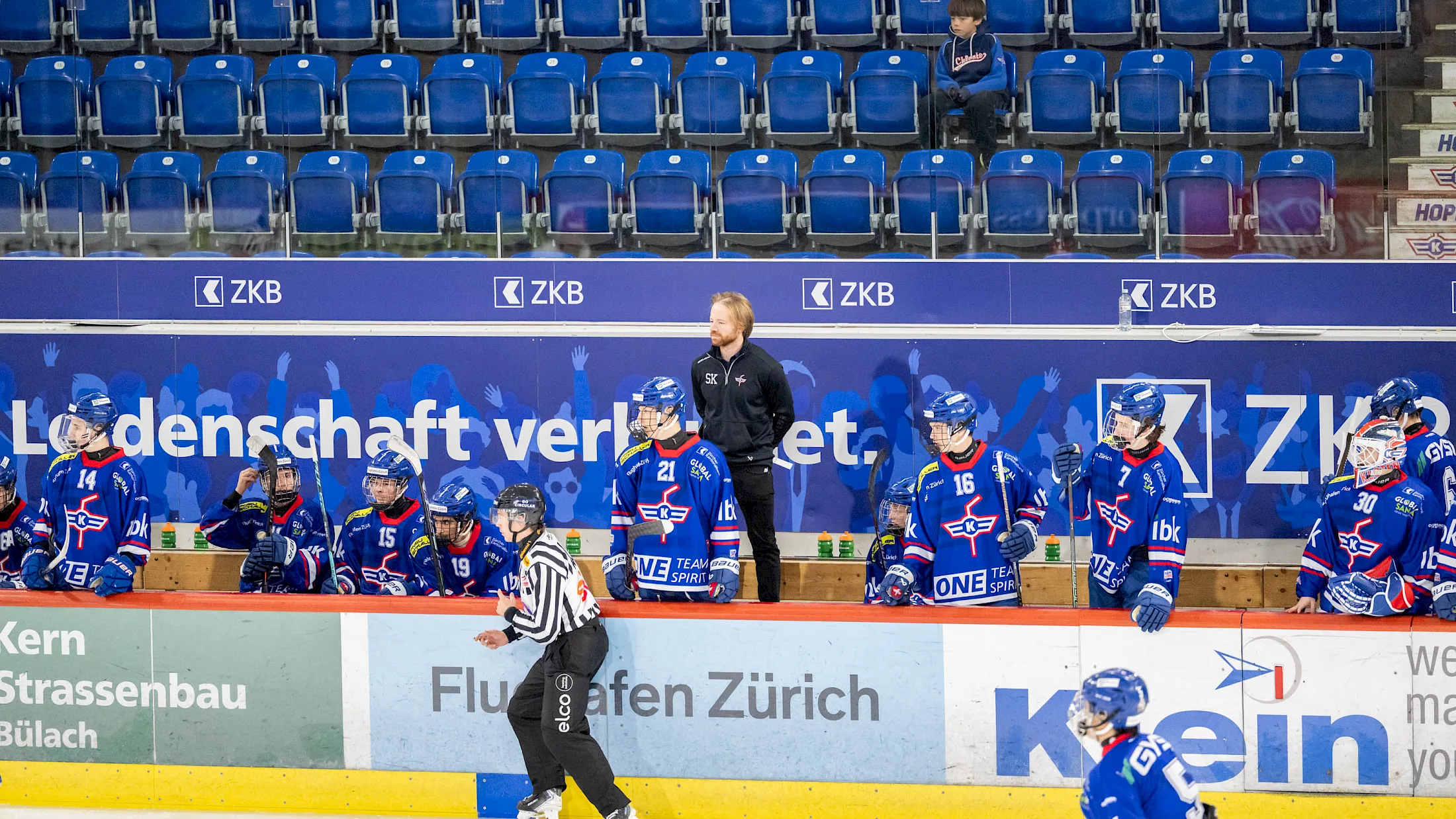 Nachwuchsspieler des EHC Kloten in blauen Trikots an der Bande feiern nach dem Spiel