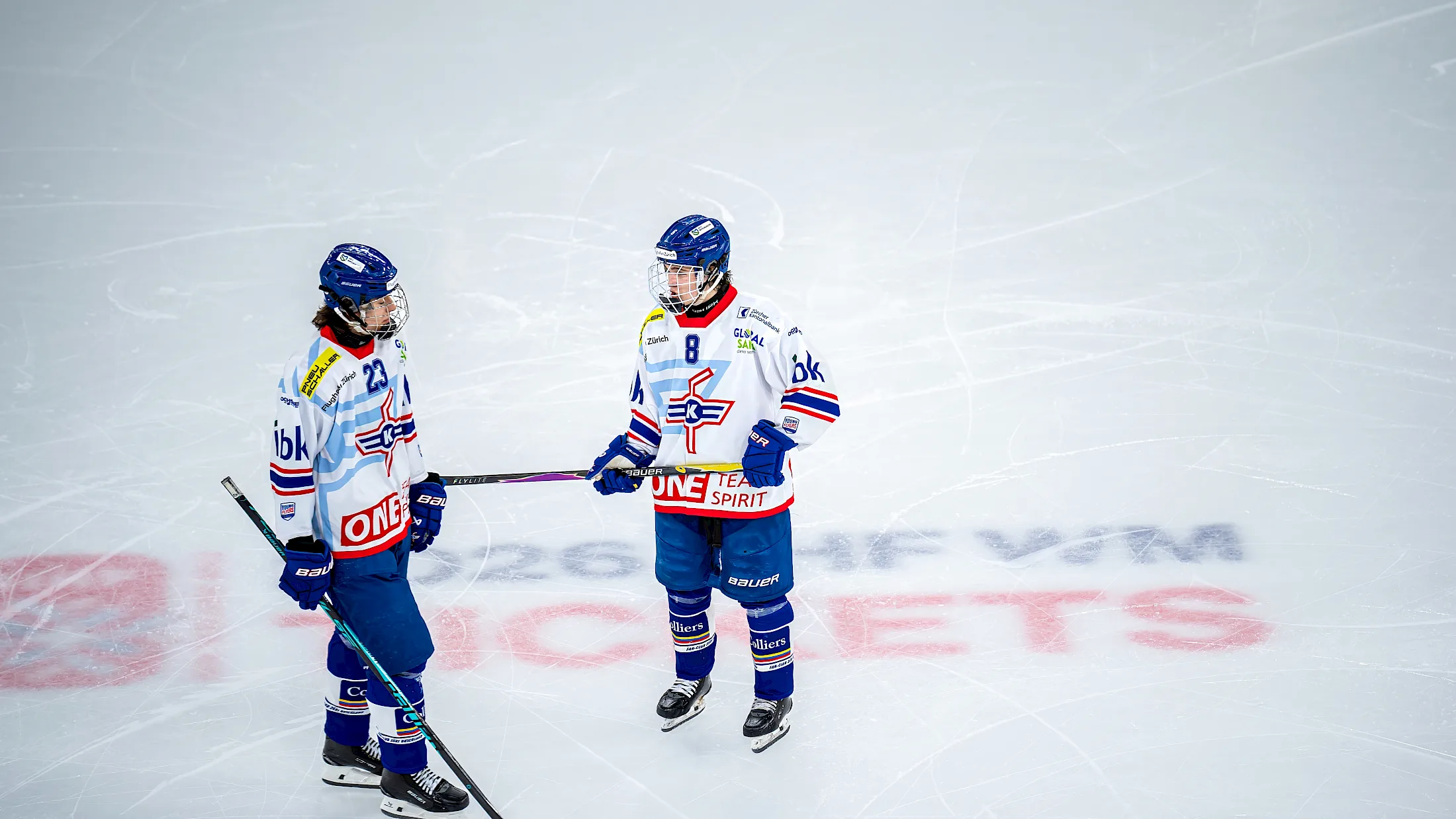 Zwei Spieler der U18-Elit im weissen Ausw&auml;rtstrikot besprechen sich auf dem Eis