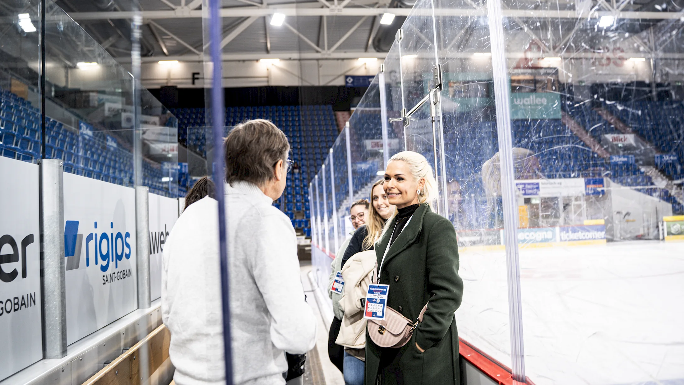 Besucherinnen und Besucher bei einer Stadiontour an der Bande der SWISS Arena